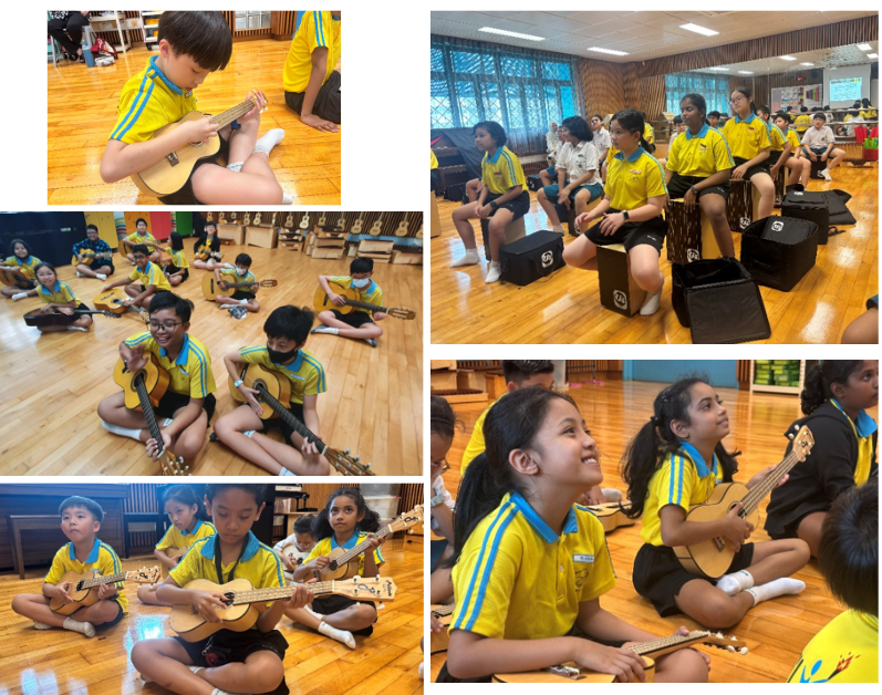 Students in yellow school uniforms sitting on the floor during a music club session, playing ukuleles and cajon drums in music room.